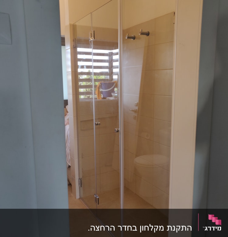 מקלחון זכוכית עם דלתות שקופות ומוט תלייה